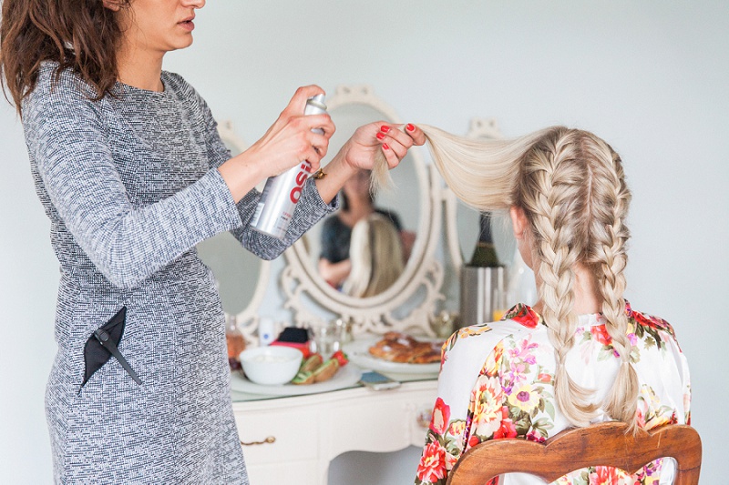 Bride getting her hair plaited on her wedding day