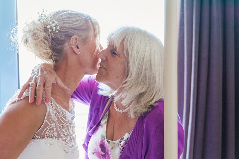 Mother and Bride Sharing a Moment Before Her Pastel Beach Wedding