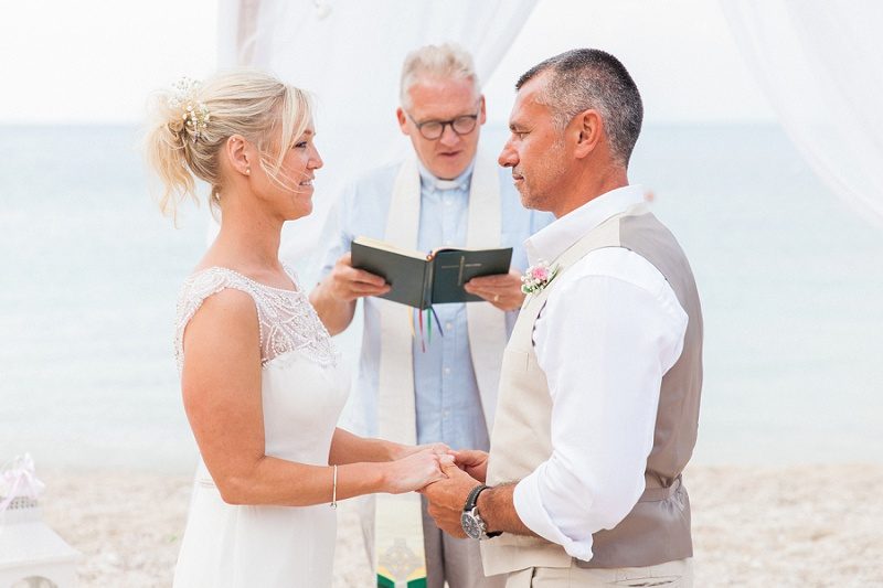 Bride and Groom Exchanging Vows During Their Pastel Beach Wedding