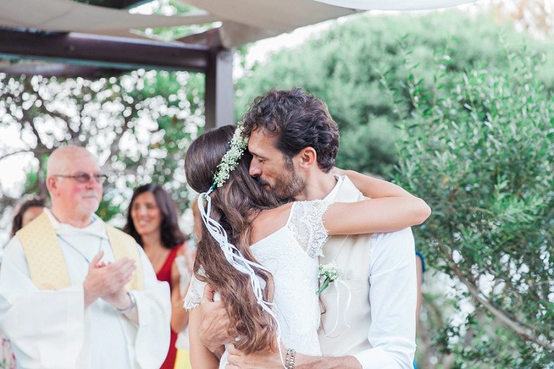 Bride and Groom Hugging After their Bohemian Garden Wedding Ceremony