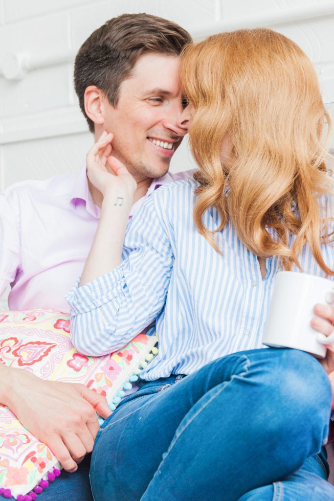 Girl draws her fiance close during their at home engagement session