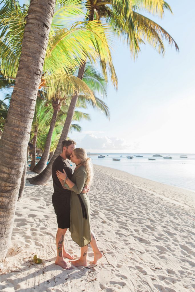 Couple hugging under the palm trees on a Mauritian beach