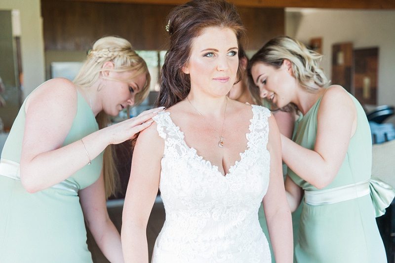 Bridesmaids Helping Bride Dress for Her Pistachio and White Wedding
