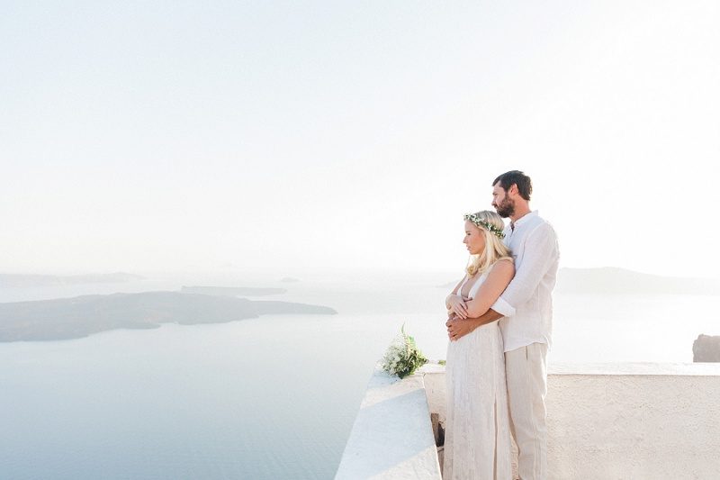 Newlywed Couple Looking Out At The View Of The Caldera In Santorini