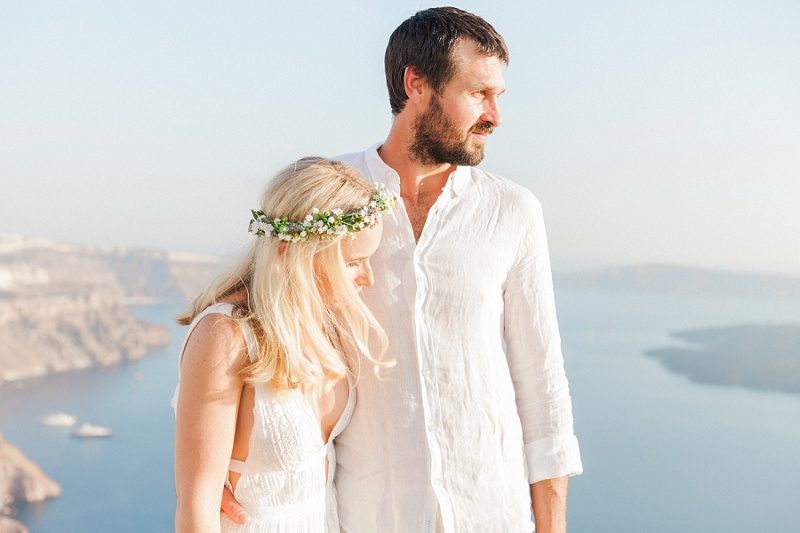Couple Standing Together With a Backdrop of the Santorini Caldera