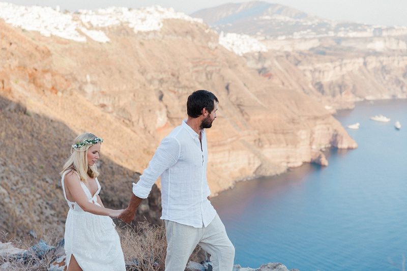 Newlyweds Walking Along the Edge of the Caldera in Santorini