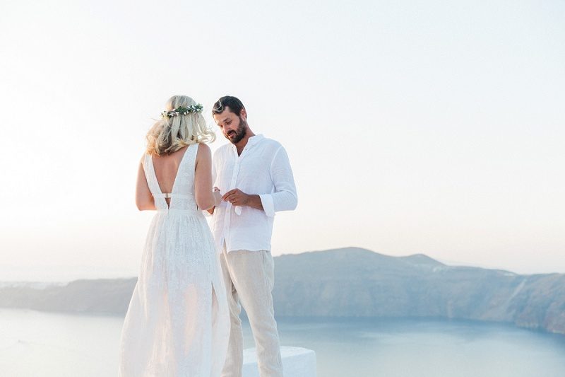 Couple Exchanging Vows During Their Sunset Elopement In Santorini