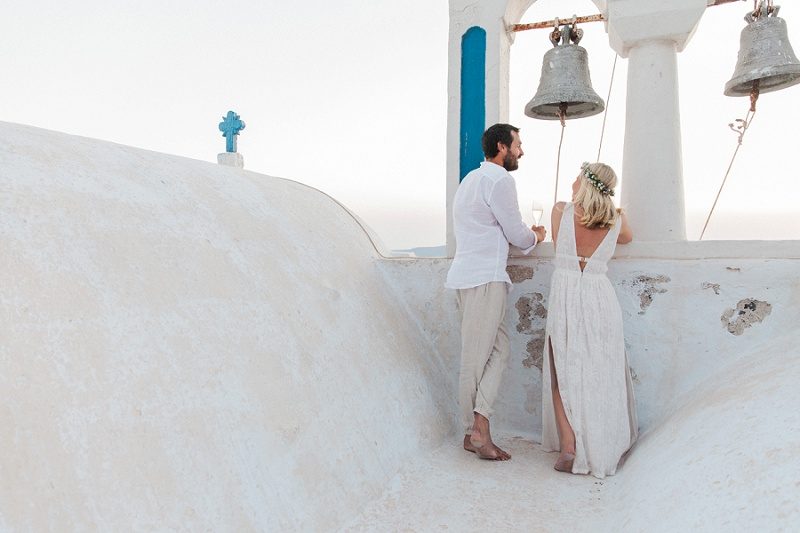 Newlyweds on a Church Roof After Their Sunset Elopement In Santorini