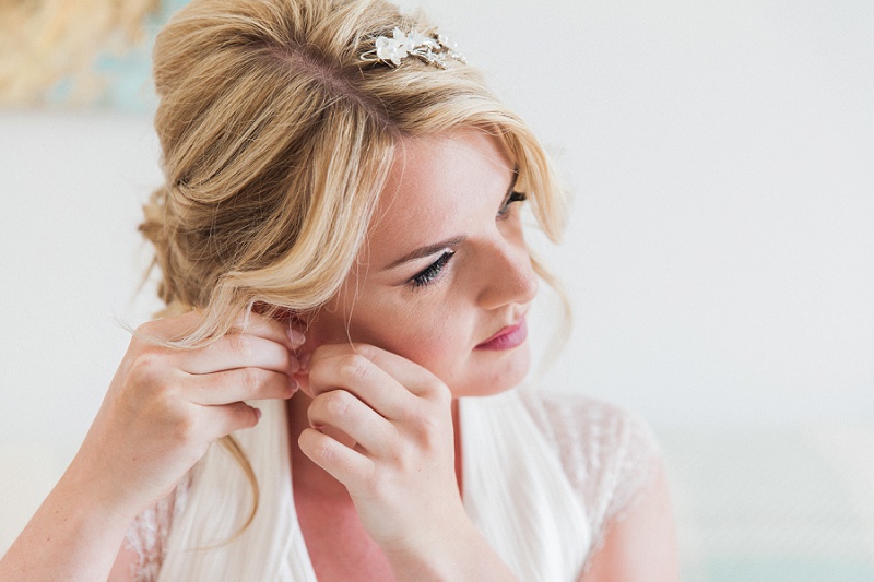 Close up of the bride putting in her crystal earrings