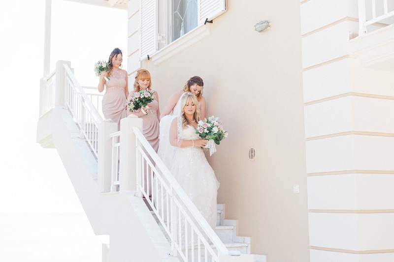 Bride and Bridesmaids making their way down the stairs of their villa to meet her father.