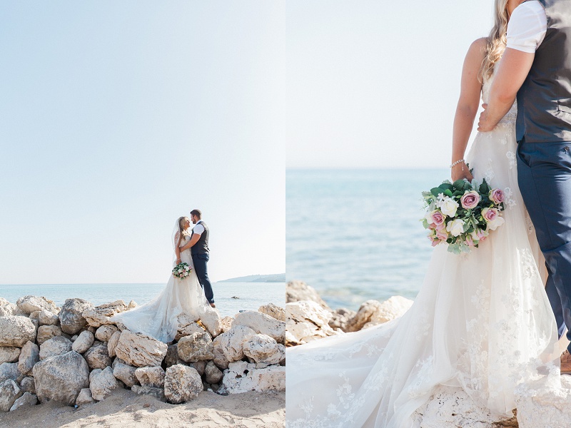 Bride and groom embrace on the rocks on a Kefalonian beach