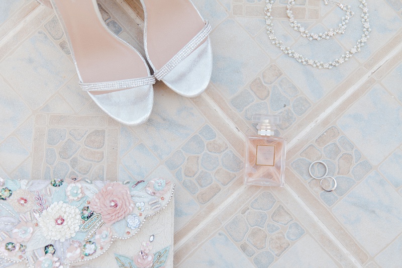 Brides details including heels, perfume and jewellery, laid out on the gorgeous pastel tiles