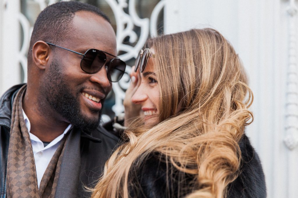 Bride to be gives her fiance a mischievious look from under her glasses during their London engagement shoot