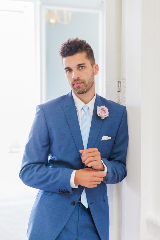 Portrait of the groom in a blue suit on the morning of his wedding at 10-11 Carlton House Terrace in London