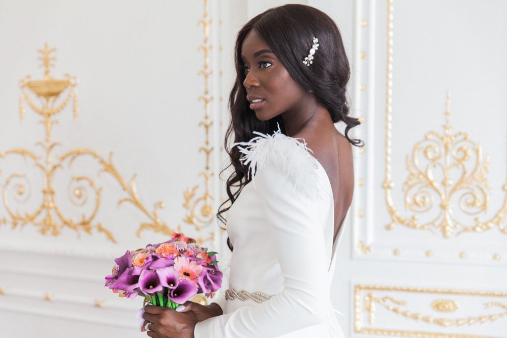 Black bride standing in the ornate doorway of 10-11 Carlton House Terrace on the day of her wedding in London