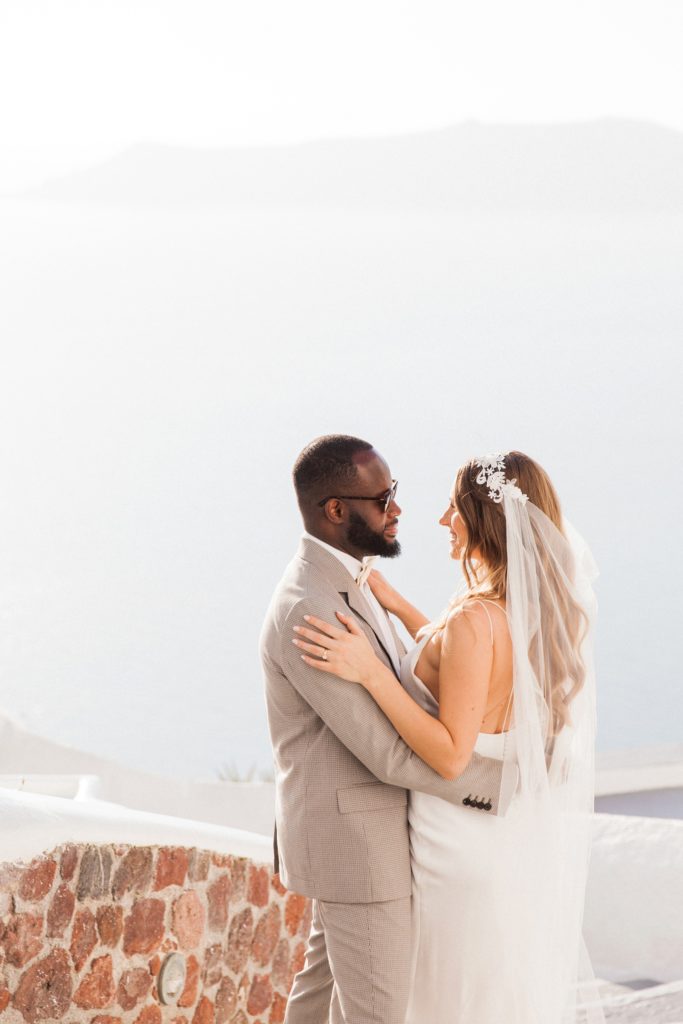 Bride and groom in Santorini against a veiw of the caldera