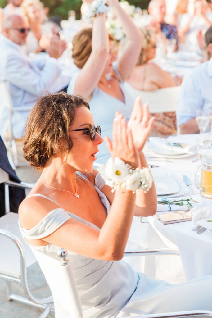 Wedding guest in pale blue dress clapping during speeches