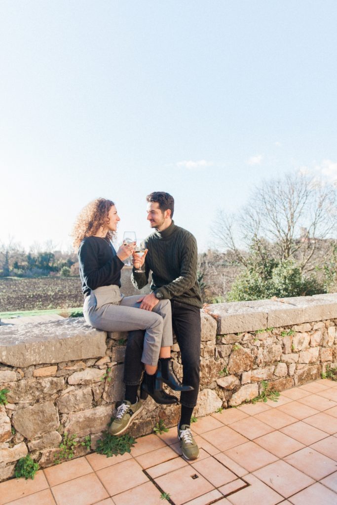 Couple enjoy a wine in the sunshine in Sermoneta, Italy