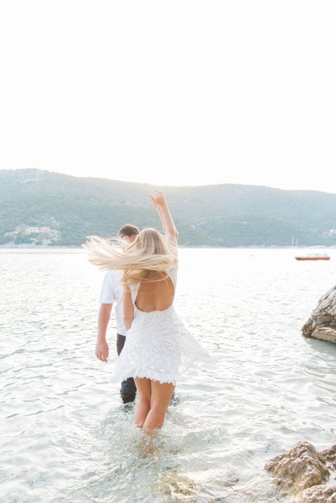 Couple dancing in the sea during their honeymoon photography session on Lefkada