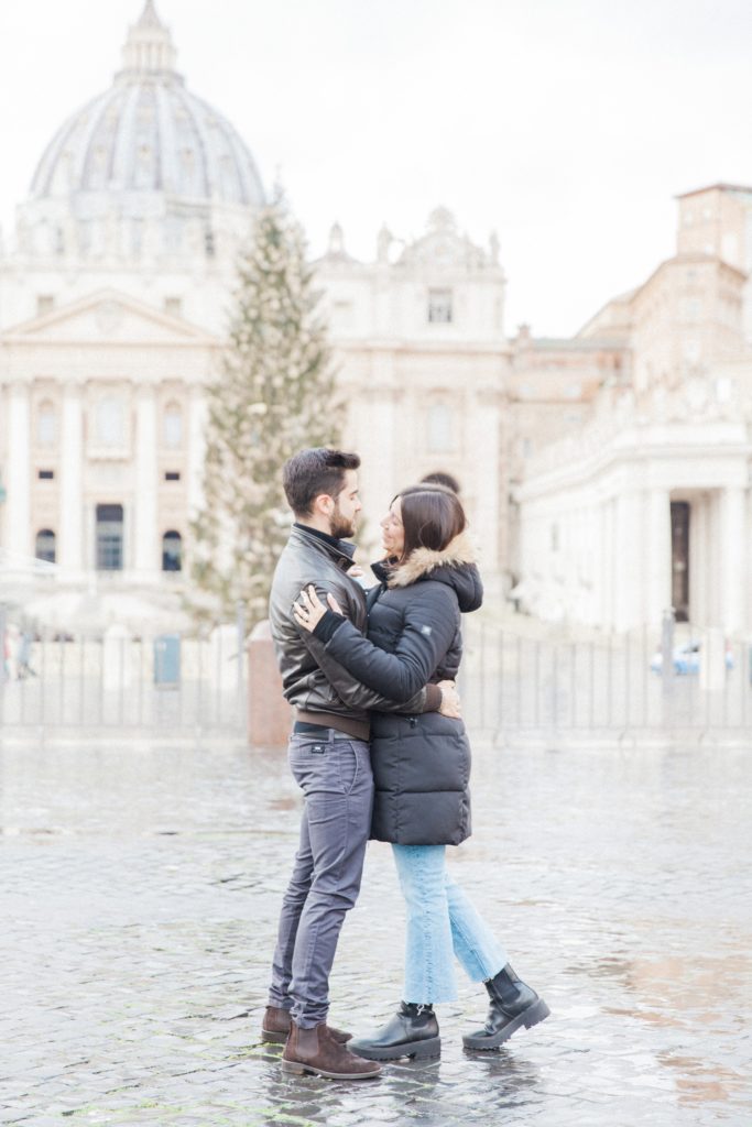 Couple embrace in front of St. Peter's basilica during their Rome couple photography session