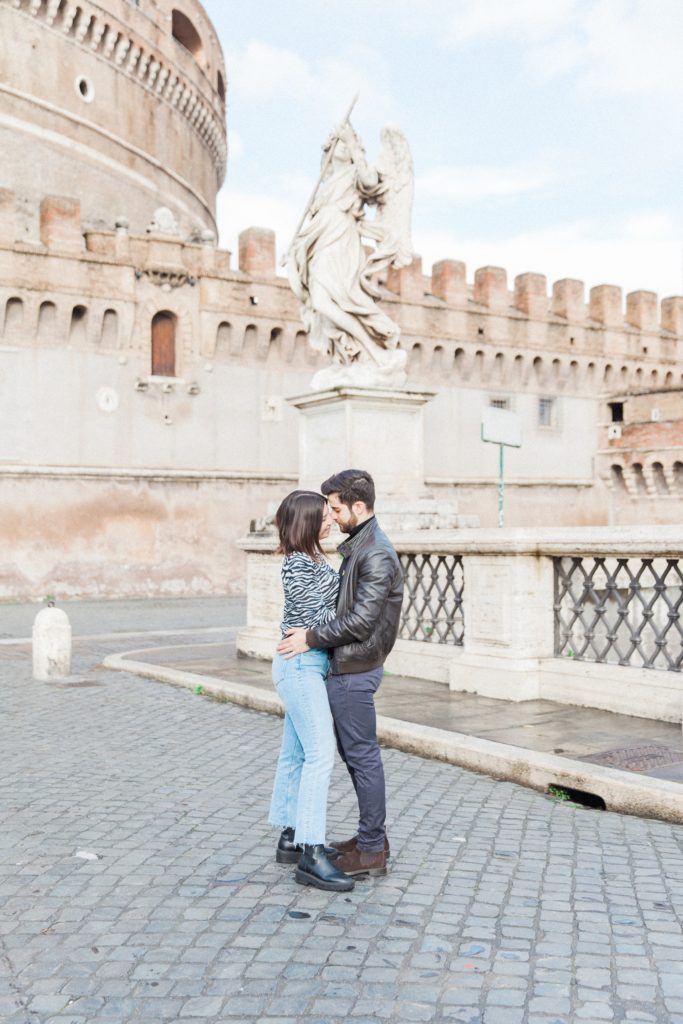 Couple kiss on the bridge in front of Castel Sant'Angelo in Rome, Italy