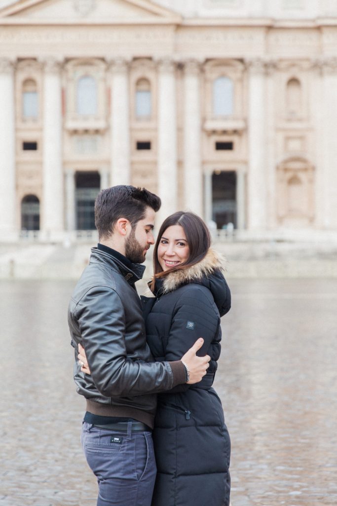 Couple hug during their Rome couple photography session at St. Peter's Basilica