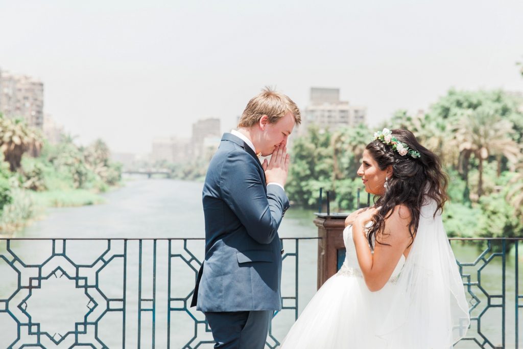 Groom reacts to seeing the bride at their First Look on a bridge over the Nile River in Cairo