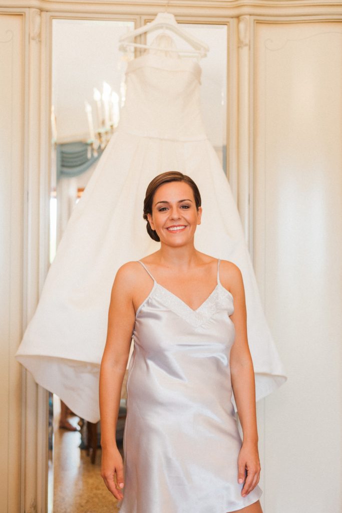 Italian bride smiles as she stands in front of her Pronovias gown