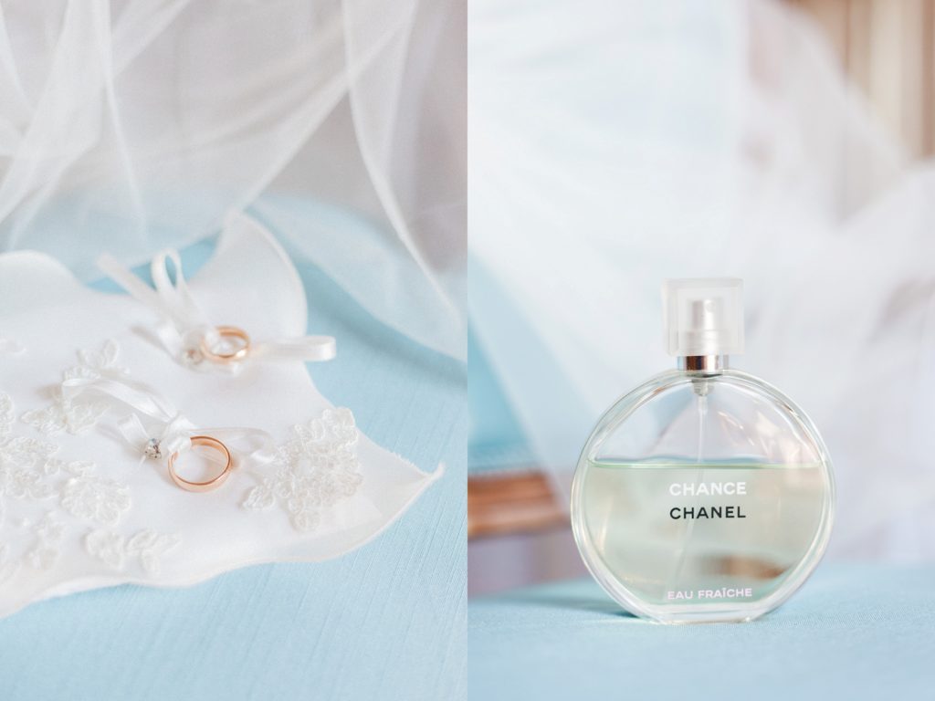 The couples gold wedding bands on a cushion and the brides Chanel Chance fragrance