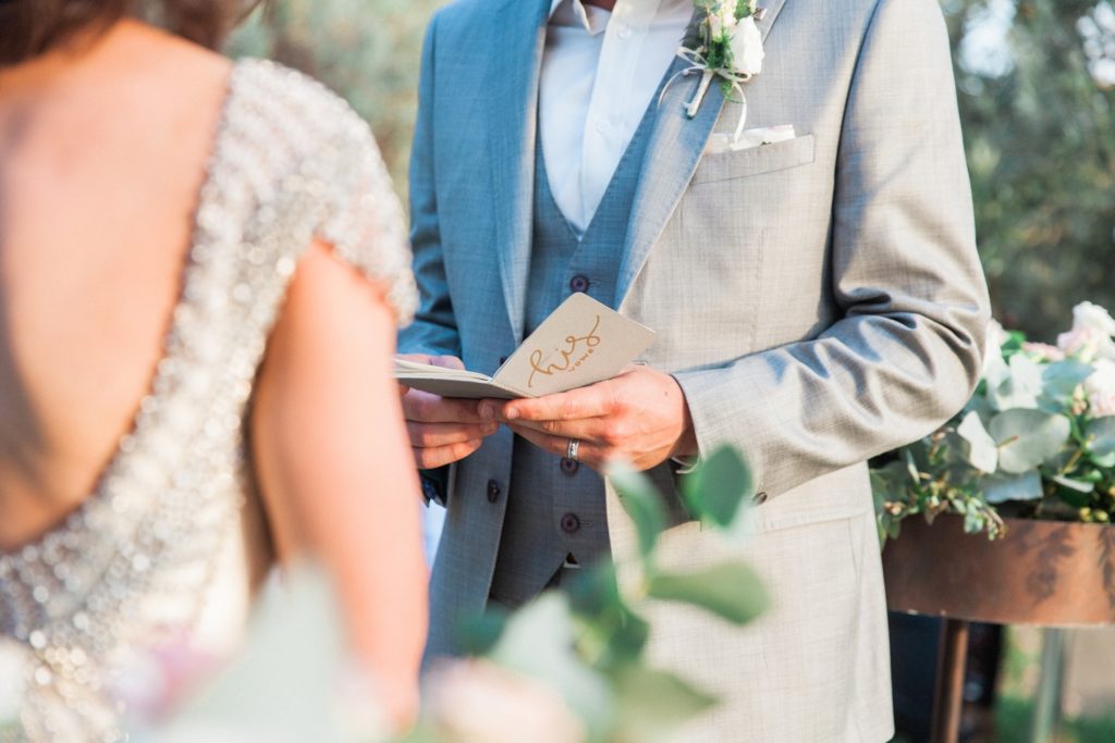 Close up of a grooms vow book during his wedding ceremony