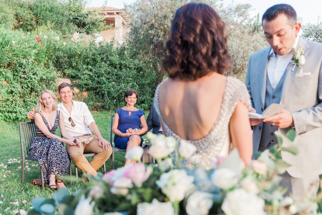 Guests smile as couple exchange vows during their destination wedding ceremony