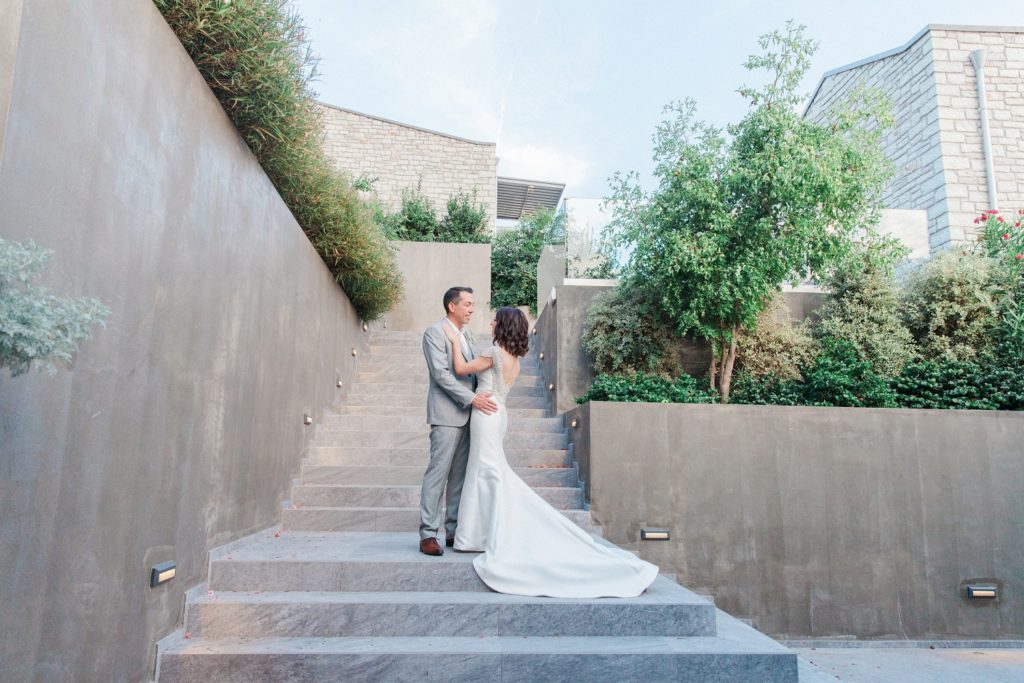 Bride and groom on the steps to the suites at Domotel Agios Nikolaos in Sivota Greece