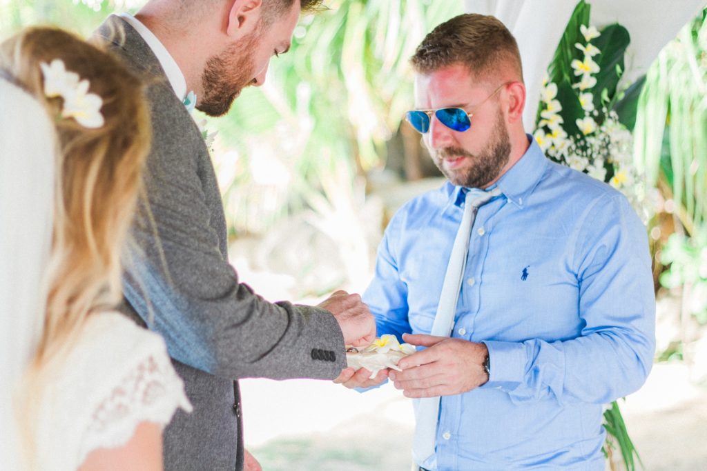 Groom takes the ring from his best man during his destination wedding ceremony