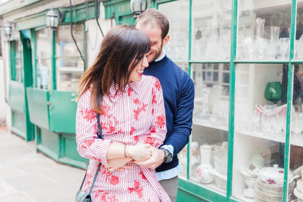 Couple hug in front of an antiques store in London