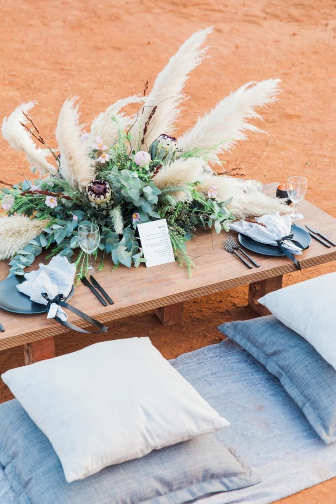 Picnic style wedding table with grey cushions and pampas grass styled by Oh Happy Day in South Africa
