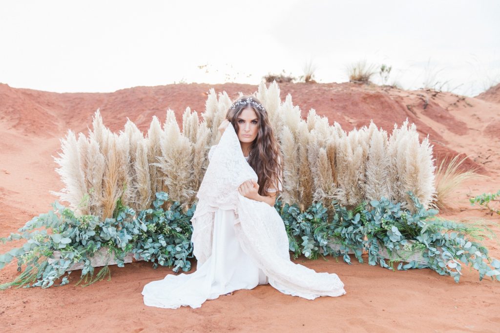 Boho bride in a Chanelle Wright gown in front of a pampas and eucalyptus arch in the Red Desert