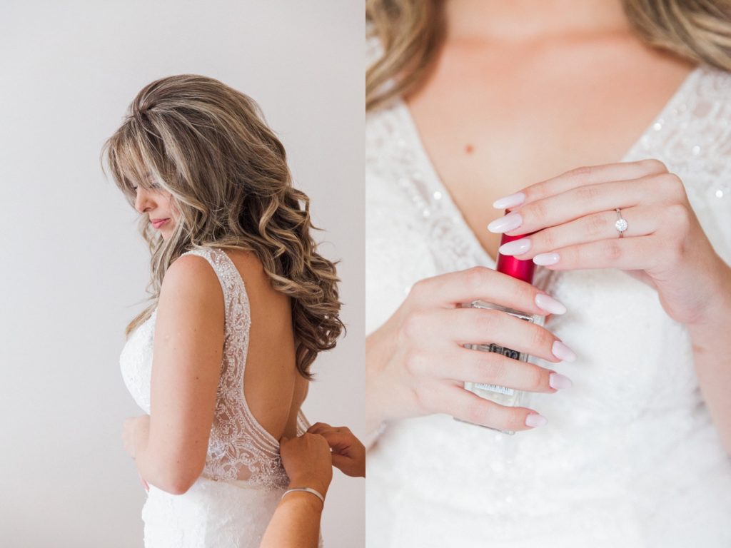 Bride putting on her dress and holding her perfume on the morning of her wedding