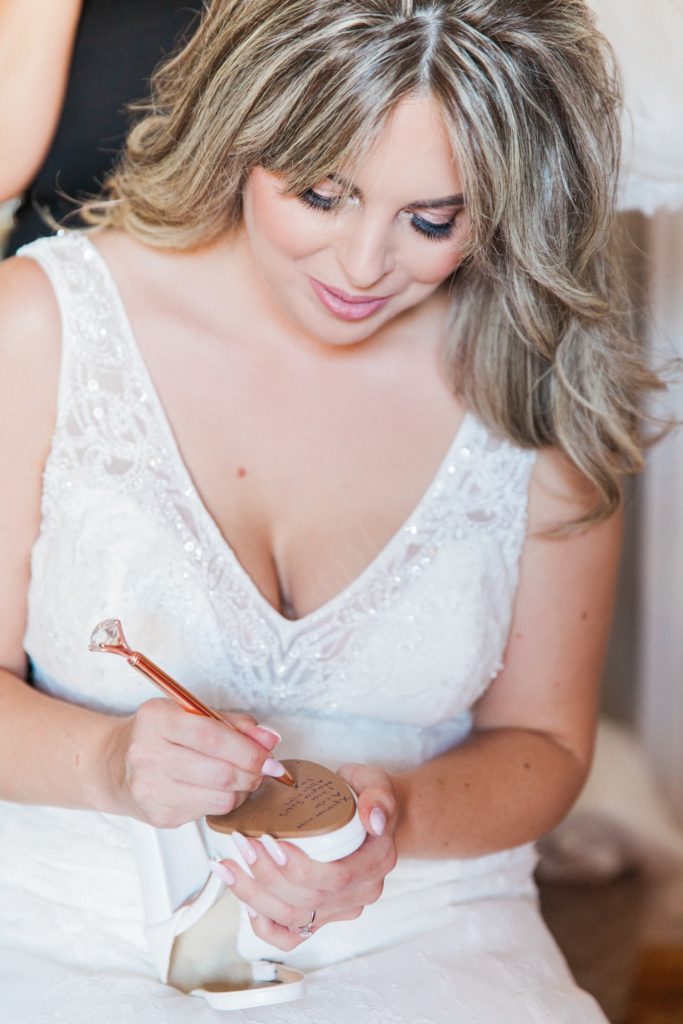 Bride writing her friends names on the bottom of her shoe on the morning of her wedding