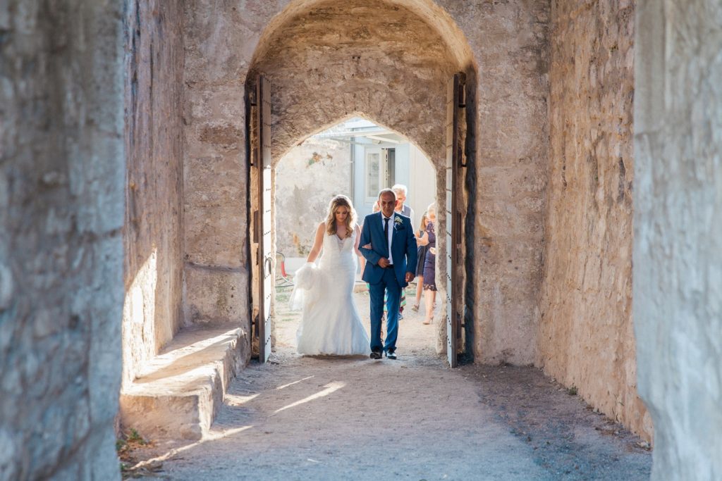 Bride and her father making their way to the church inside Santa Maura Castle in Lefkada