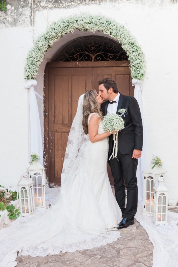 Couple kiss in front of the door of the church inside Santa Maura Castle in Lefkada