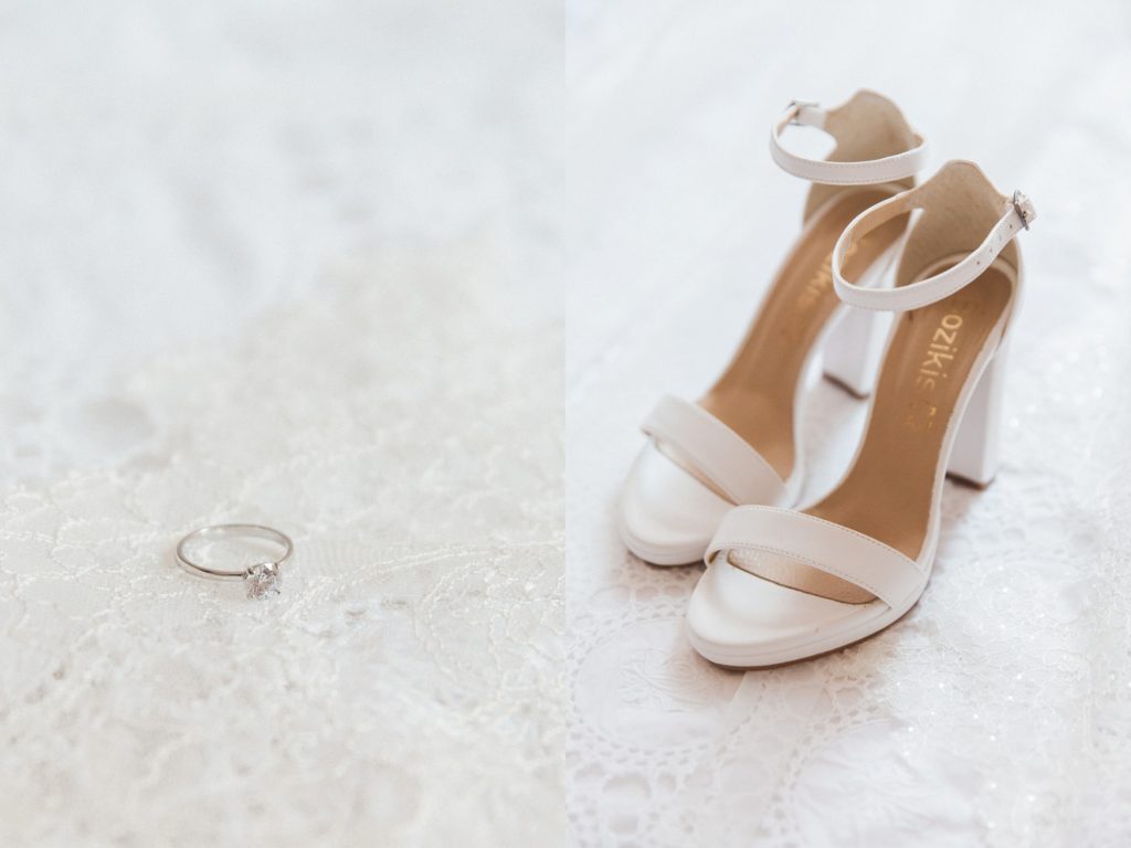 Diamond engagement ring and the brides wedding shoes on white lace