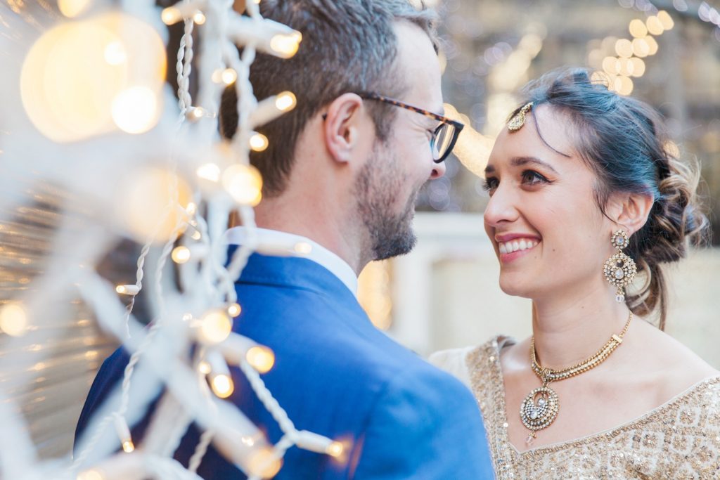 Portrait of a bride and groom amongst fairy lights in London