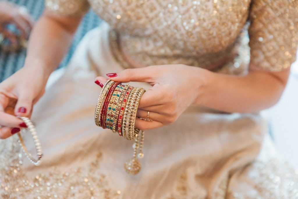 Indian bride putting on her bangles on the morning of her South Place Hotel wedding