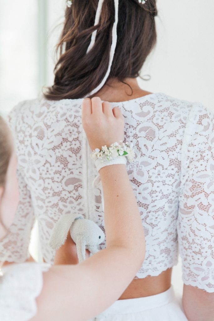 Daughter helps her mother into her wedding gown on the morning of her villa elopement
