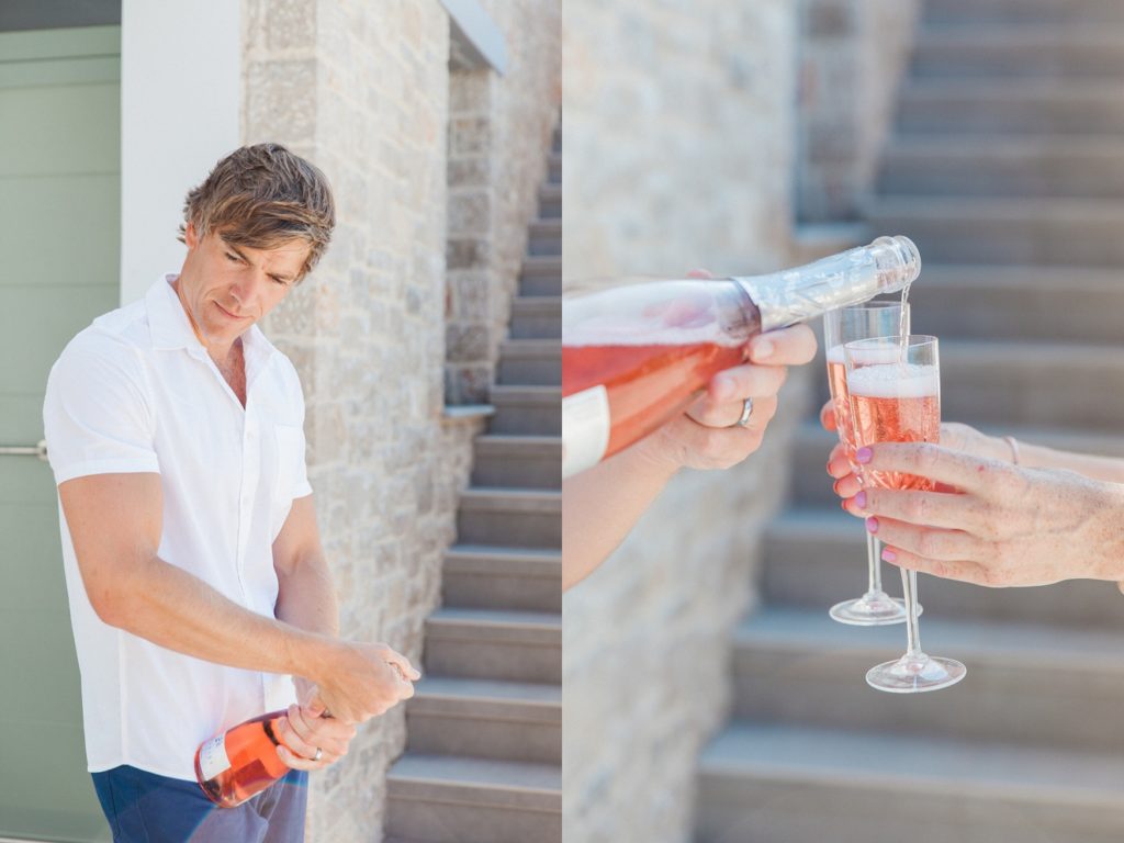 Groom opening and pouring pink prosecco
