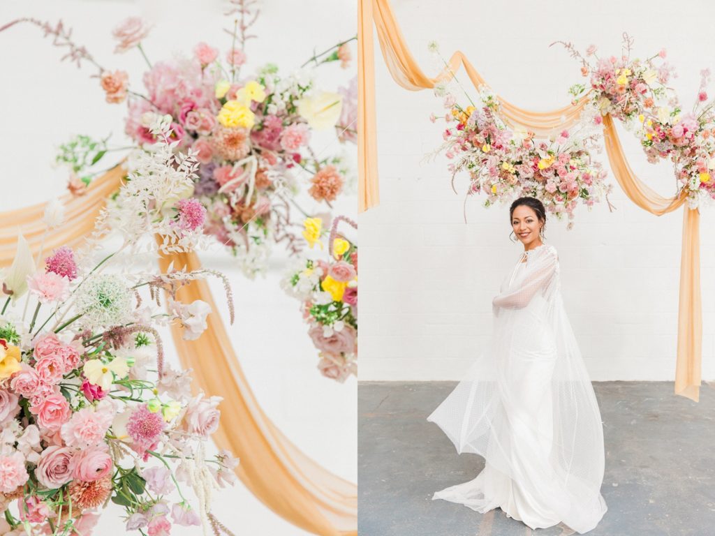 Spring inspired hanging flower arrangements above a bride wearing a Halfpenny London gown