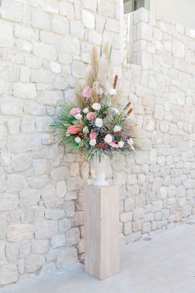 Pastel wedding flowers with bullrushes in a stone urn at Crystal Waters Lefkada