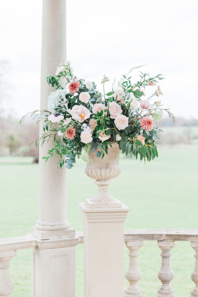 Pastel flower arrangement in an urn for a Beatrix Potter inspired wedding at Froyle Park