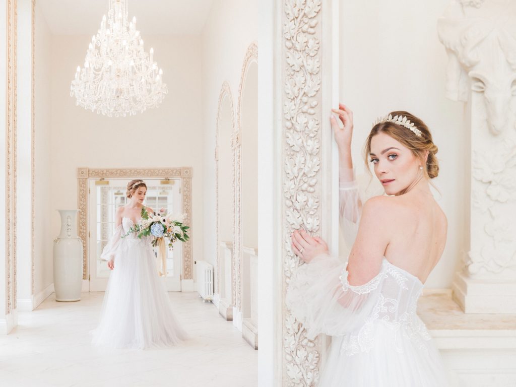 Bride in a Chic Nostalgia gown poses under a chandelier in a marble corridor
