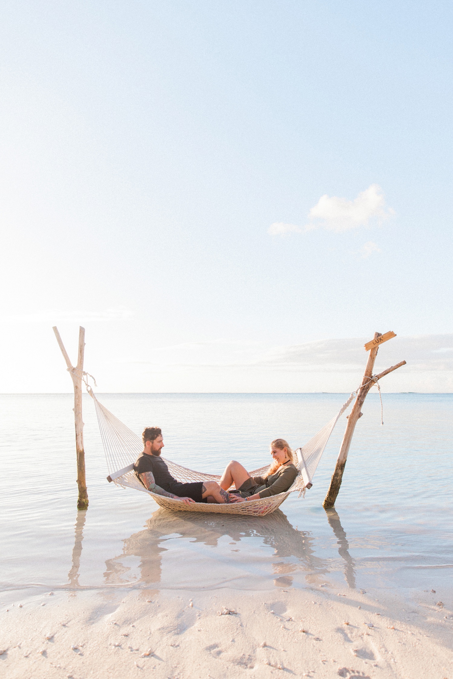 Couple in a hammock at sunset during their Mauritius engagement session